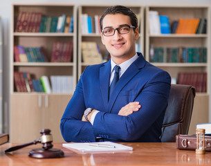 Handsome judge with gavel sitting in courtroom