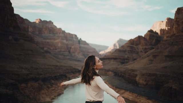 Traveler feels free in Grand Canyon in Arizona, looking round, enjoying power of nature, river between cliffs of canyon