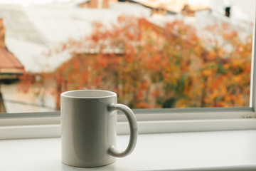 Cup of coffee at the edge of the windows in the morning.