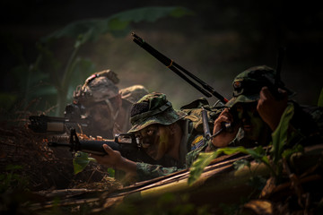 Soldier with gun are hiding in the forest and are ready for fighting. War, soldier army, gun and...