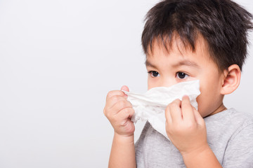 Closeup Asian face, Little children boy cleaning nose with tissue