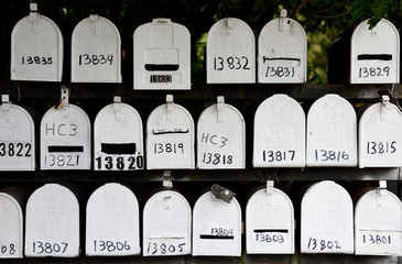 Several rows of white metal numbered United States post office mailboxes