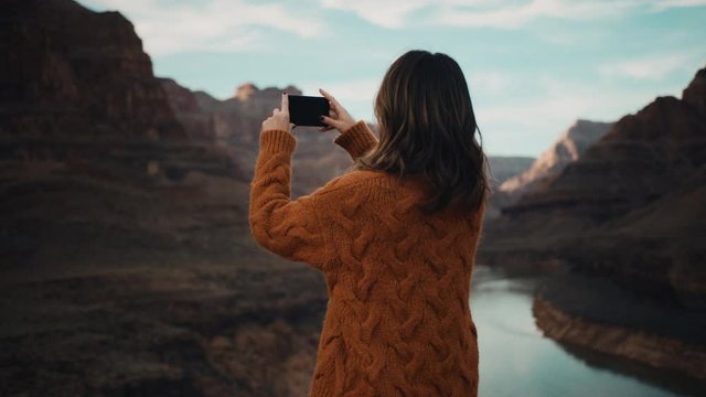 Traveler takes pictures of Grand Canyon in Arizona, river between mountains, famous natural landmark, traveling around the United States 