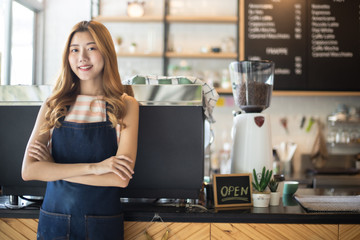 Fototapeta na wymiar Portrait young Asian woman barista feeling happy smiling at urban cafe. Small business owner Korean girl in apron relax toothy smile