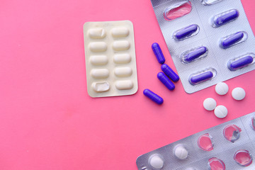 top view of pills and capsule on pink background 