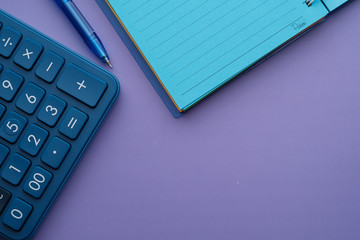 top view of calculator,pen and notepad on table 