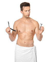 Fototapeta premium Handsome young man with different razors on white background