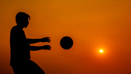 Silhouette practicing with the football during sunset background slow motion