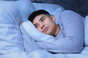 Asian man suffering from insomnia at night