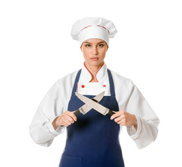 Beautiful female chef with knives on white background