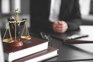 Scales of justice with law books on table of notary public in office