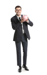 Fototapeta premium Happy male bank manager with piggy bank on white background