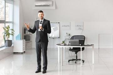 Male journalist with microphone indoors