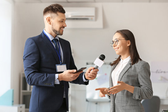 Male journalist having interview with woman indoors