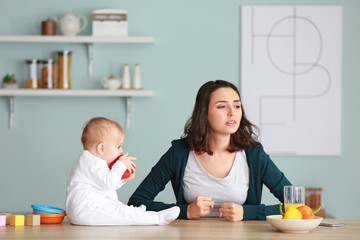 Young woman suffering from postnatal depression at home