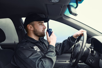 Male police officer driving car