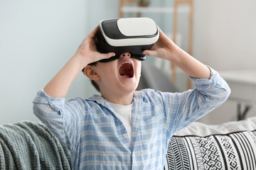 Little boy with virtual reality glasses at home