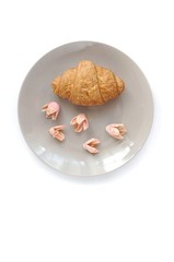 Croissant with decorated flowers in the grey plate top view