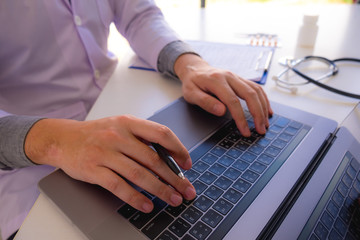 The doctor sat on the table, worked, checked the patient's documents.Sit, study, research, treat, research in treatment.