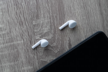 Fototapeta premium earphones in her ear, listens to music. girl smiling, looking into her phone. gadget smartphone