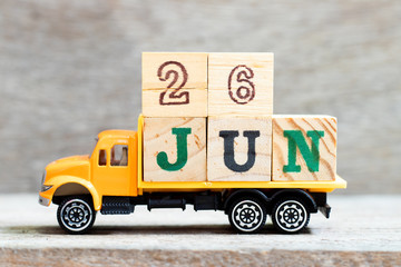 Truck hold letter block in word 26jun on wood background (Concept for date 26 month June)
