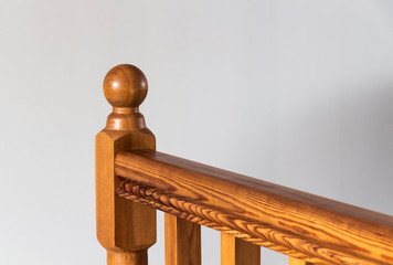 Element of a wooden interior staircase. Wooden baluster close-up.