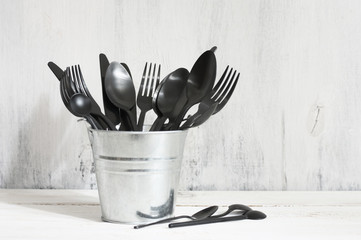 Set of black cutlery in galvanized bucket