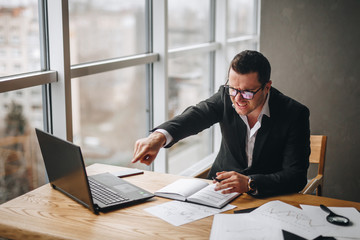 very angry businessman guy shows a finger at subordinate in the office at the table