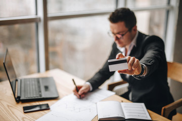 bank employee shows a credit card in his left hand