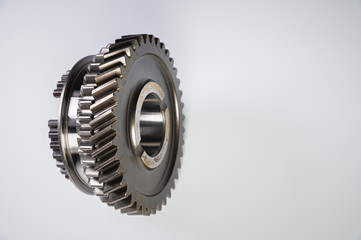 New parts on a gray background. Gears of gear shifting torque transmission. Conceptually mechanical background. Shiny gear box gear teeth