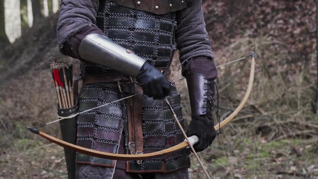 Medieval archer draws arrow and shooting bow, middle age concept
