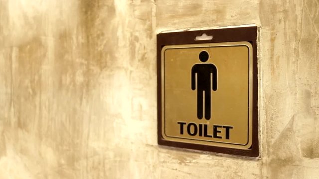 Motion of man washroom logo beside vintage cement loft wall, Toilet sign stuck on the old concrete wall.