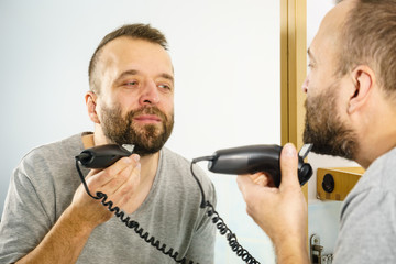 Man shaving trimming his beard
