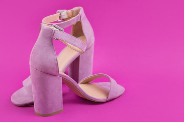 a pair of female pink high-heeled shoes stand on a bright pink background, concept, close-up shot, selective focus