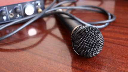 Black microphone rests on wooden surface