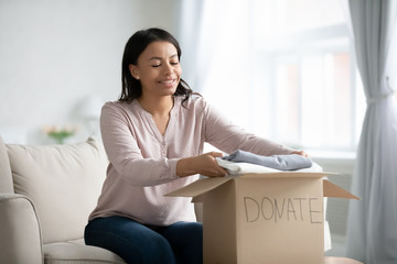 African American female volunteer put clothes in donation box