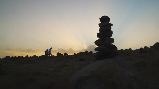 Concept of balance and harmony. Stack of stones pebbles cairn on the beach coast of the Atlantic on sunset. Meditative art of stone stacking in Cani&ccedil;al, Madeira island, Portugal.
