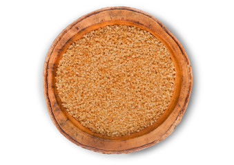 Wooden bowl of natural brown refined sugar on white background.