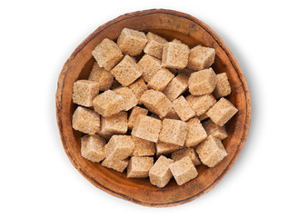 Wooden bowl plate of natural brown sugar cubes on white background.