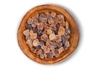 Wooden bowl of natural brown caramelized sugar cubes on white background.