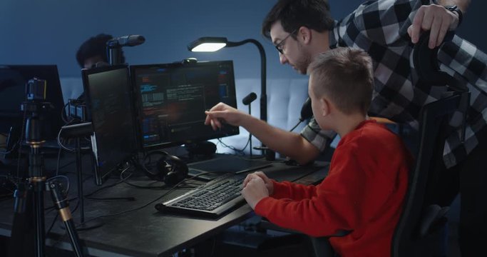 Child programmer getting instructions from colleague