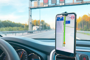 The smartphone in the car is used for navigation or GPS. The movement of the car with a smartphone...
