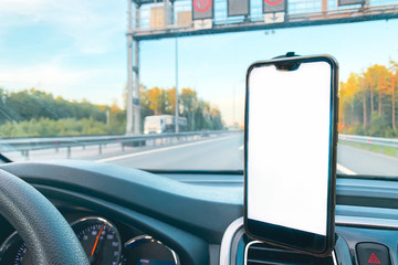 The smartphone in the car is used for navigation or GPS. The movement of the car with a smartphone...