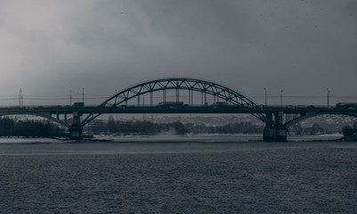 Road bridge in cloudy weather on the background of the Moscow river.