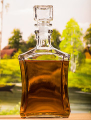 Whiskey in a decanter against a background of natural flame and black.