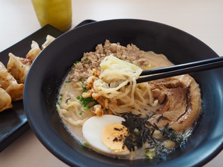 Tonkotsu ramen topping with Chaashu , Nori , Negi, tamago eat with Gyoza and ice cold green tea