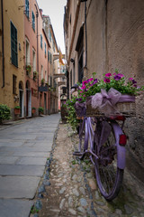 Fototapeta na wymiar Flower bike in Finalborgo medieval village, Liguria region, Italy