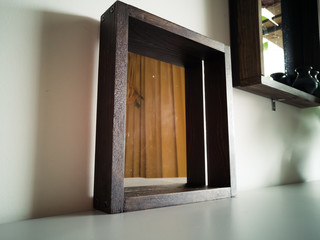 Close up of wooden stained mirror against the wall.