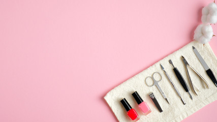 Manicure and pedicure tools set with cotton on pink background. Flat lay, top view. Nail salon...