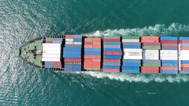 Aerial of cargo ship carrying container and running verry fast for export cargo from  cargo yard port to other ocean concept smart freight shipping ship on blue sky background.  forwarder mast